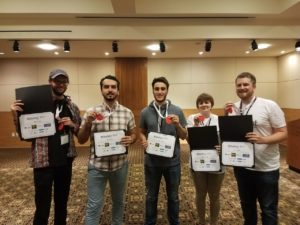 Five victorious csun students hold up certificates and medals in a hotel conference room