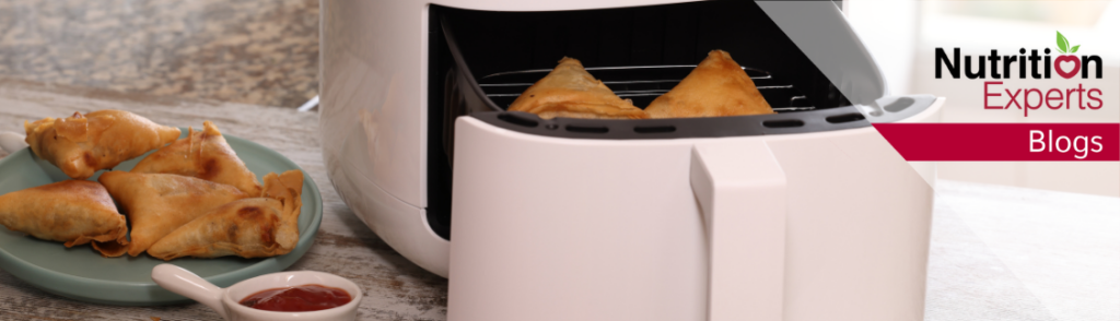 Image of an air fryer with air-fried simosas.